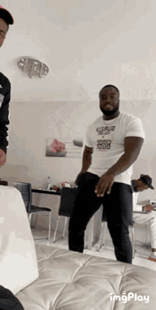 a man wearing a white shirt that says 1000 rode is dancing
