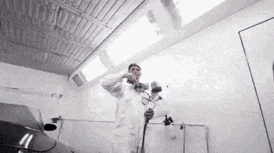 a man is spray painting a car in a paint booth .
