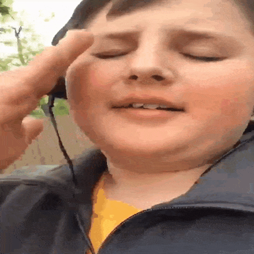 a young boy wearing headphones is making a face