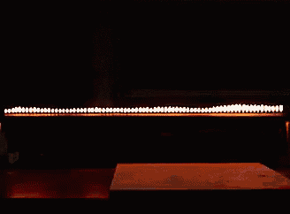 a candle is burning on a table in the dark .