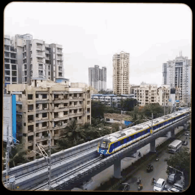 a train is going down a track in a city with buildings in the background .