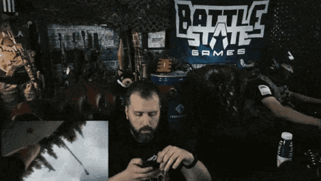 a man playing a video game in front of a battle state games sign