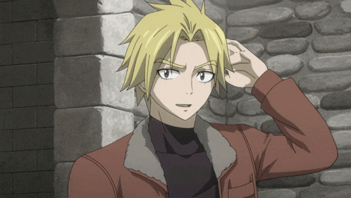 a man with blonde hair is standing in front of a brick wall