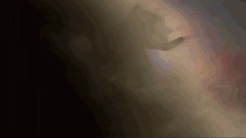 a dark background with a light shining through the smoke