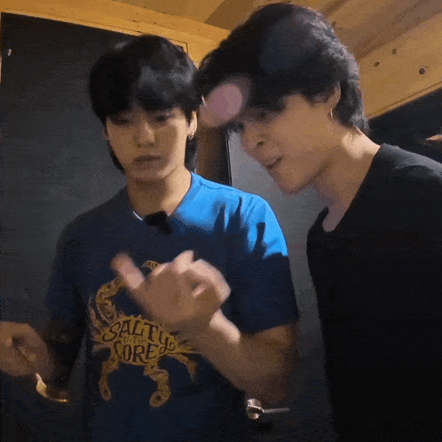 two men are standing next to each other and one of them is wearing a blue shirt that says salt to the sore