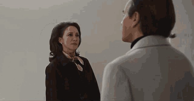 a man and a woman are standing next to each other and looking at each other in a room .