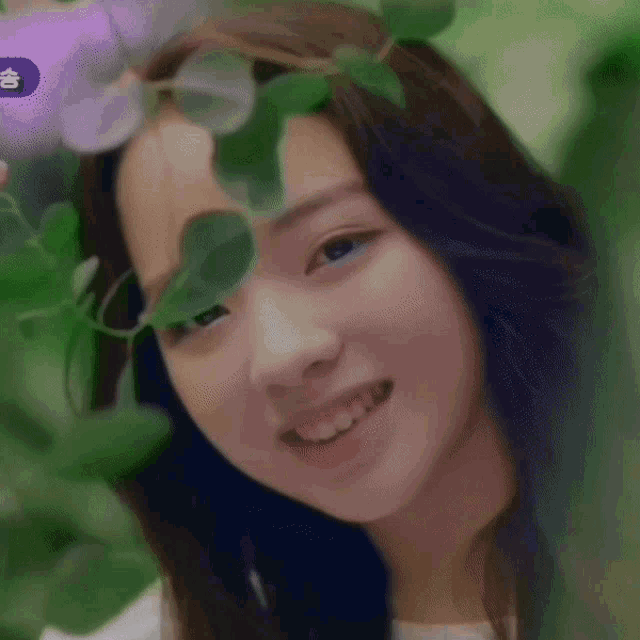 a woman with a flower crown on her head smiles