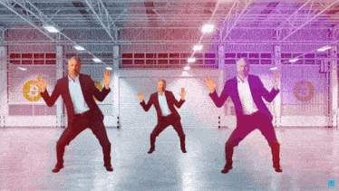 three men in suits are dancing in a warehouse with a bitcoin symbol in the background
