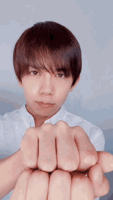 a young man making a heart shape with his hands