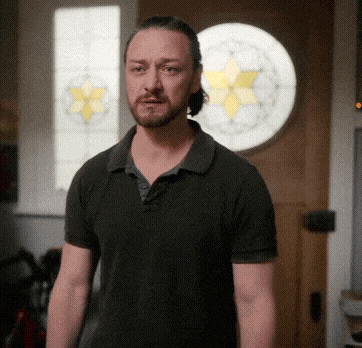 a man in a black shirt is standing in front of a stained glass door