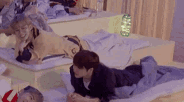 a group of people are laying on their stomachs on mattresses in a room .