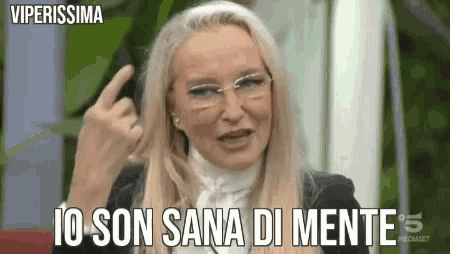 a woman wearing glasses is giving the middle finger and saying i 'm son sana di mente .
