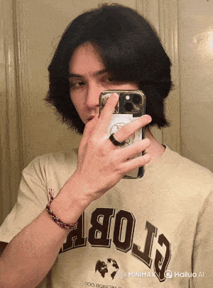 a man wearing a shirt that says apollo is taking a selfie with his phone