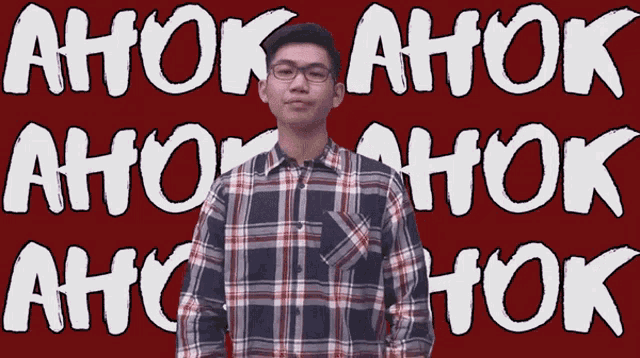 a man in a plaid shirt stands in front of a red background that says ahok ahok ahok ahok ahok