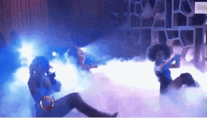 a woman singing into a microphone on a stage with smoke coming out of her mouth