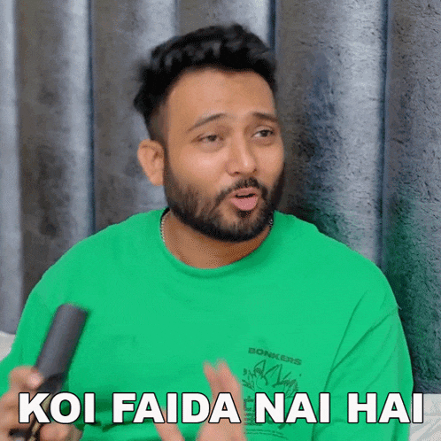a man in a green shirt is talking into a microphone and says koi faida nai hai