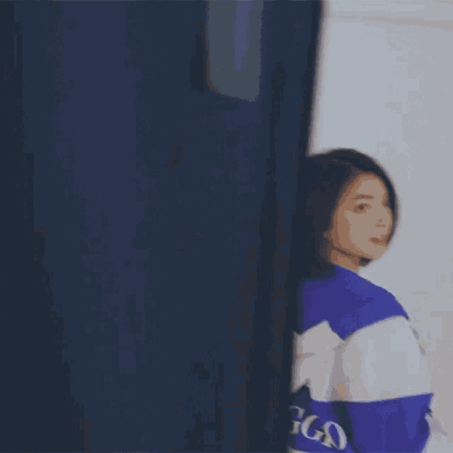 a woman is wearing a blue and white striped hoodie with the word ing on the back