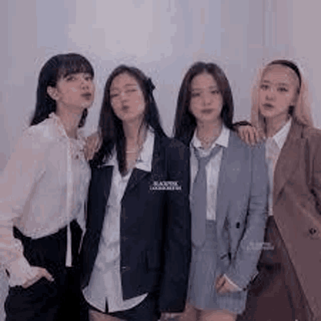 a group of women are posing for a picture together while wearing school uniforms .