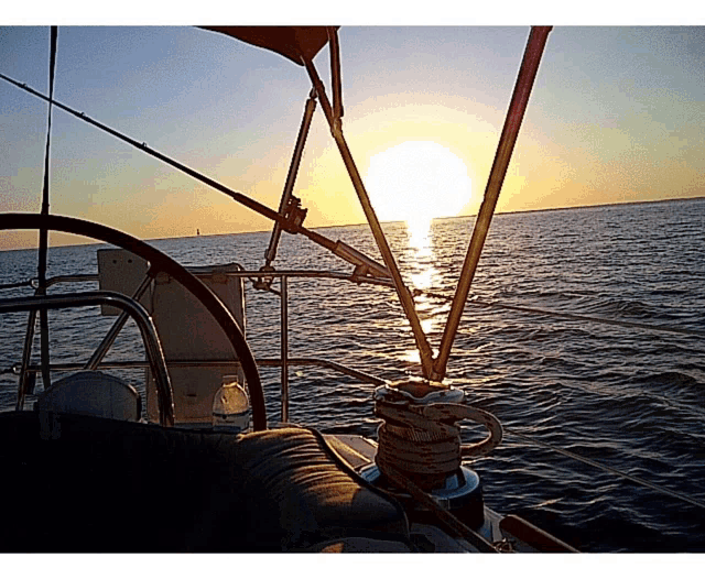 a bottle of water sits on the steering wheel of a boat in the ocean