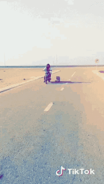 a person is riding a motorcycle on a road with tiktok written on the bottom