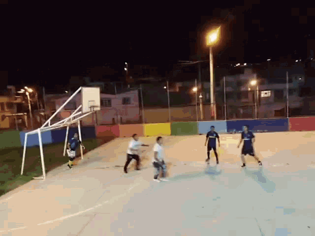 a group of people are playing a game of soccer on a court