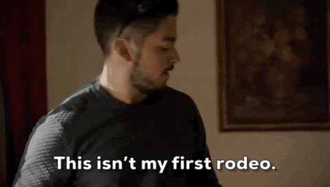 a man with a beard is standing in front of a picture and saying `` this isn 't my first rodeo . ``