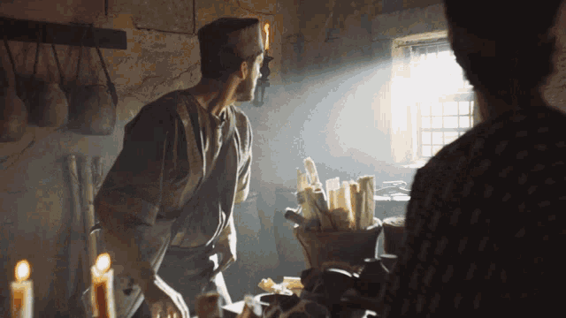 a man in an apron is standing in front of a table full of food