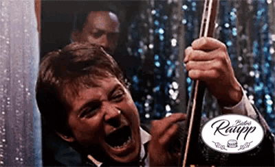 a man is screaming while holding a pool cue in front of a sign that says ' raupp '