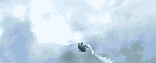 a man with wings is flying through the air in the clouds .