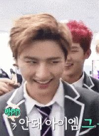 a man in a suit and tie is smiling while standing next to another man in a suit and tie .