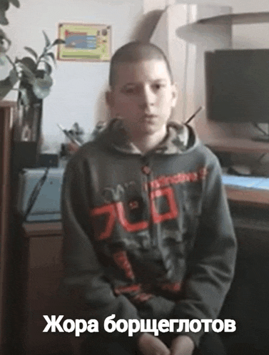 a boy wearing a hoodie that says 700 on it sits in front of a computer