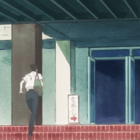 a person is walking in front of a building with a sign pointing to the left