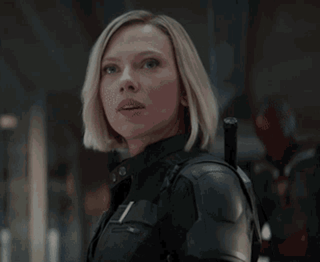 a close up of a woman in a black suit with a sword on her back