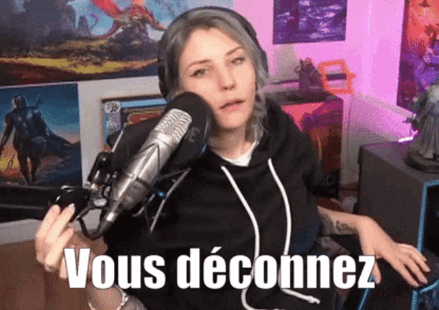 a woman holding a controller in front of a microphone with vous deconnez written on the bottom