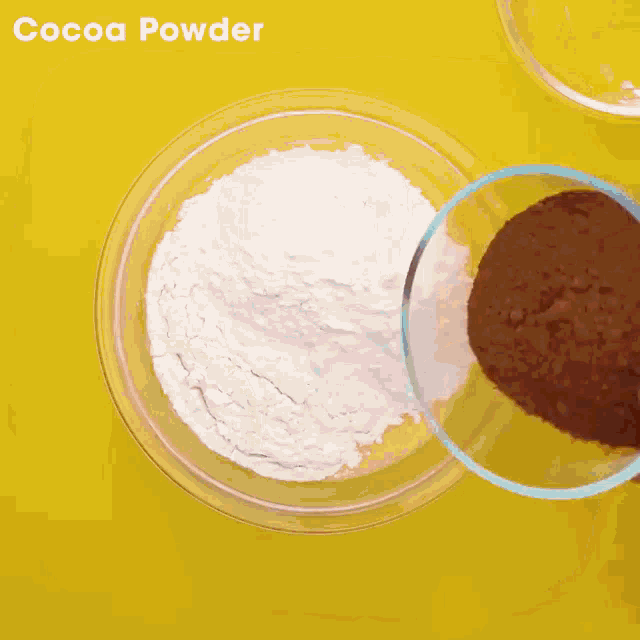 a bowl of cocoa powder is being poured into another bowl