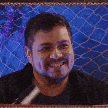 a man with a beard is smiling and looking at the camera