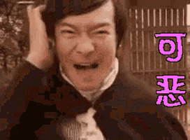a man in a suit and tie is making a funny face and holding his head .