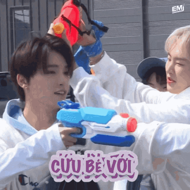 a group of young men are playing with water guns and one of them has the word cuu be voi written on it