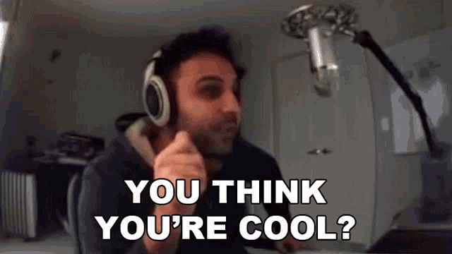 a man wearing headphones says " you think you 're cool " in front of a microphone