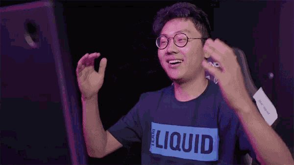 a man wearing glasses and a shirt that says liquid applauds