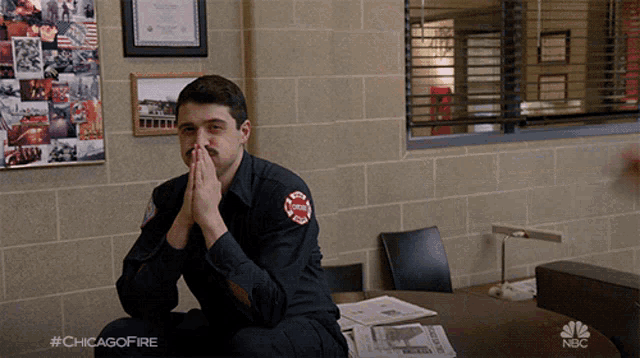 a man in a chicago fire uniform sits at a table