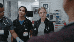a group of doctors and nurses are standing in a hallway with a sign on the wall that says ar