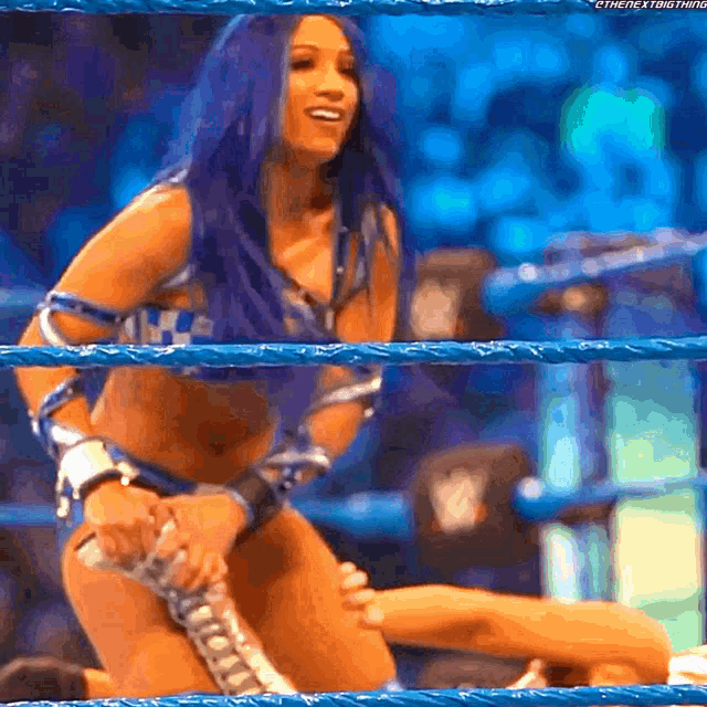 a woman with purple hair is holding a rope in a wrestling ring ..