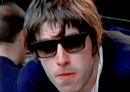 a man wearing sunglasses and a blue jacket looks down