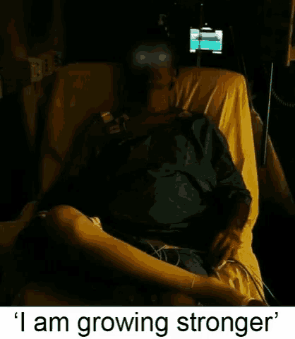 a man in a hospital bed with the words i am growing stronger