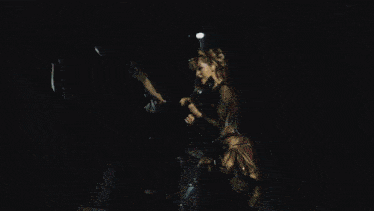 a man playing a guitar and a woman playing violin on a stage