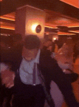 a man in a suit and tie dancing in a dark room
