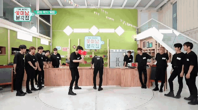 a group of young men are standing in a room with a sign that says " the boys "