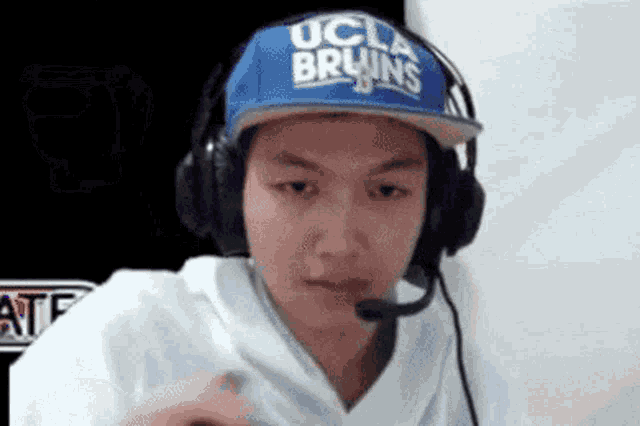 a young man wearing headphones and a blue hat with the word bruins on it .