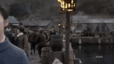 a woman in a blue coat is standing in front of a torch .